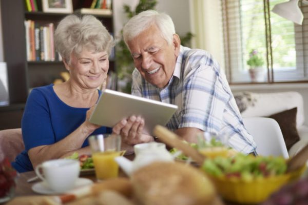 Modern couple of elder people using a touch pad Modern couple of elder people using a touch pad