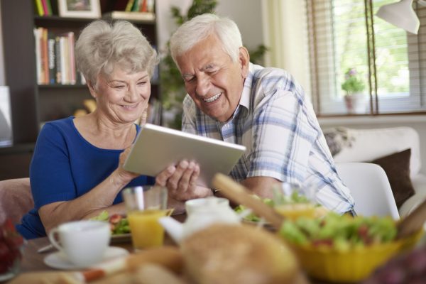 Modern couple of elder people using a touch pad Modern couple of elder people using a touch pad